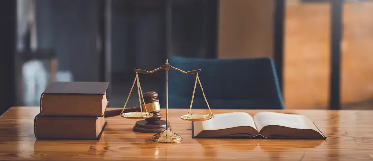 A judges's gavel next to some law books.